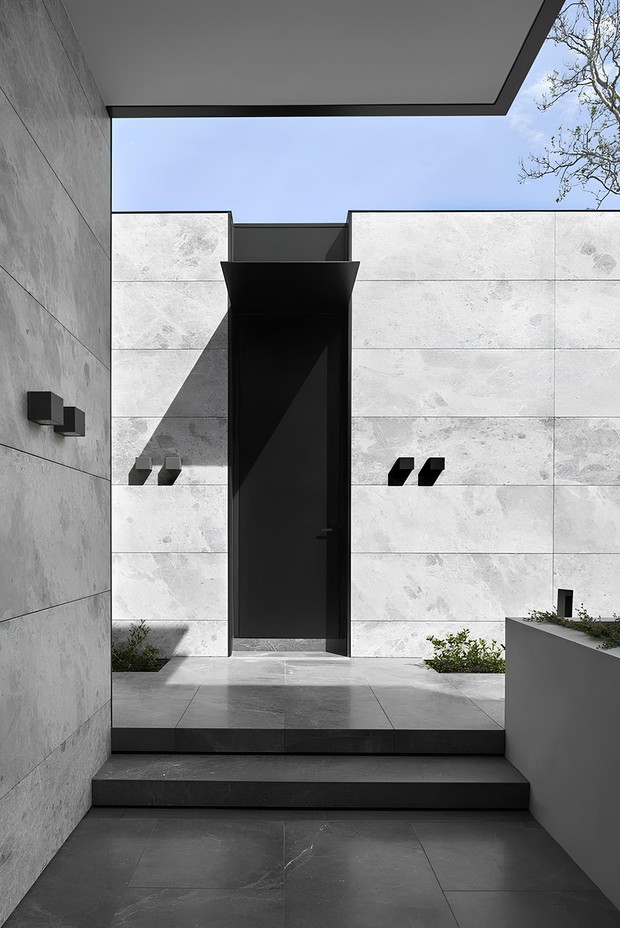 Отделка фасадов одноэтажного современного дома из керамических щелевых блоков мраморными слэбами