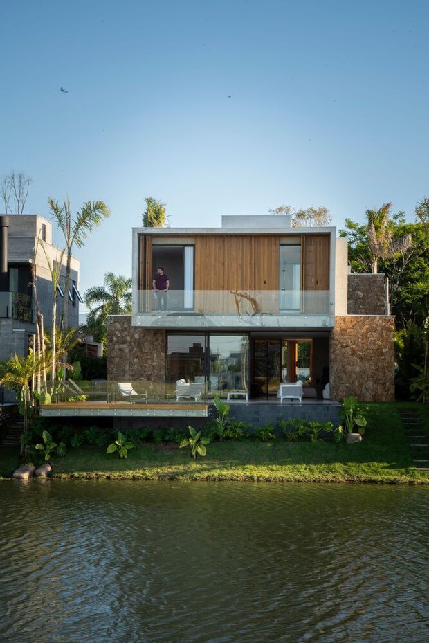 Задняя сторона дома выходит на канал, откуда открывается вид на бассейн, балкон и спальню хозяев наверху.