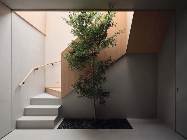 Второй этаж устроен вокруг внутреннего садика; расположенные вокруг двери тонко интегрированы в отделку микроцементных стен.