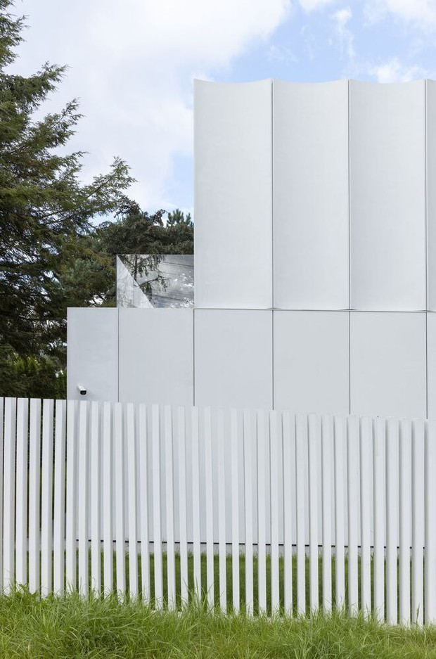 Фрагмент фасада на фоне частого ритма элементов ограждения