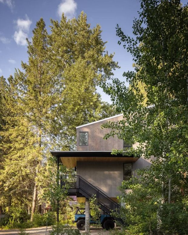 Дом на бетонных колоннах создаёт защищённое пространство для работы с винтажным Bronco на пойменном участке.