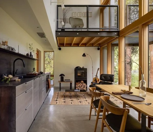 Средний уровень объединяет кухню с кастомными стальными поверхностями и обеденную зону у панорамного окна.